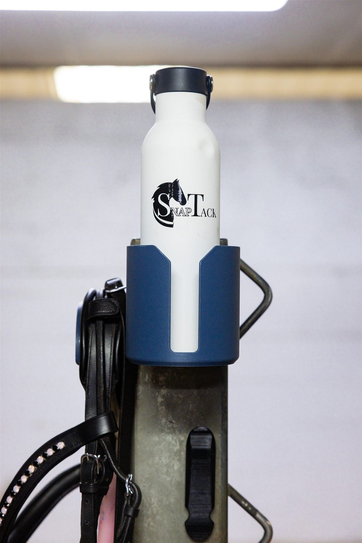 Navy magnetic bottle holder keeping a drink handy while grooming