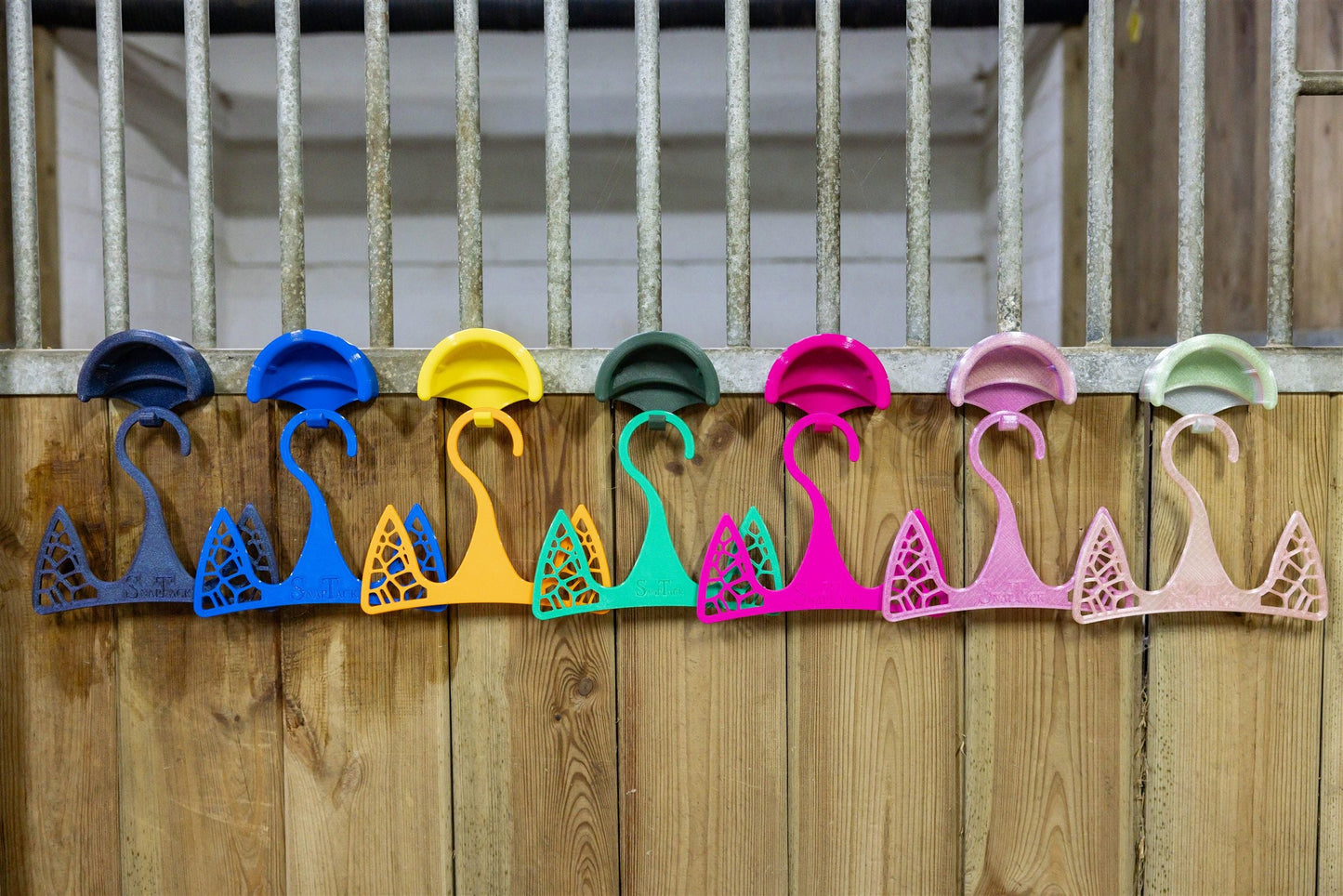 SnapTack magnetic bridle holders in a rainbow of colours snapped onto a stable wall